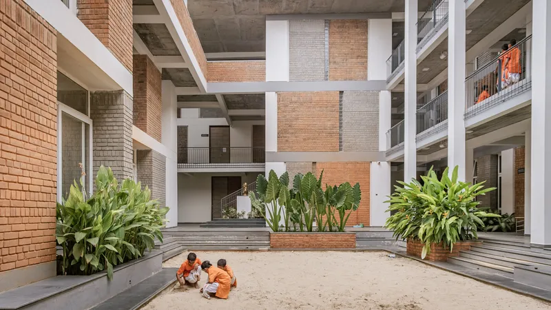 Sunken sand courtyard with tiered seating and planted beds as children gather in center