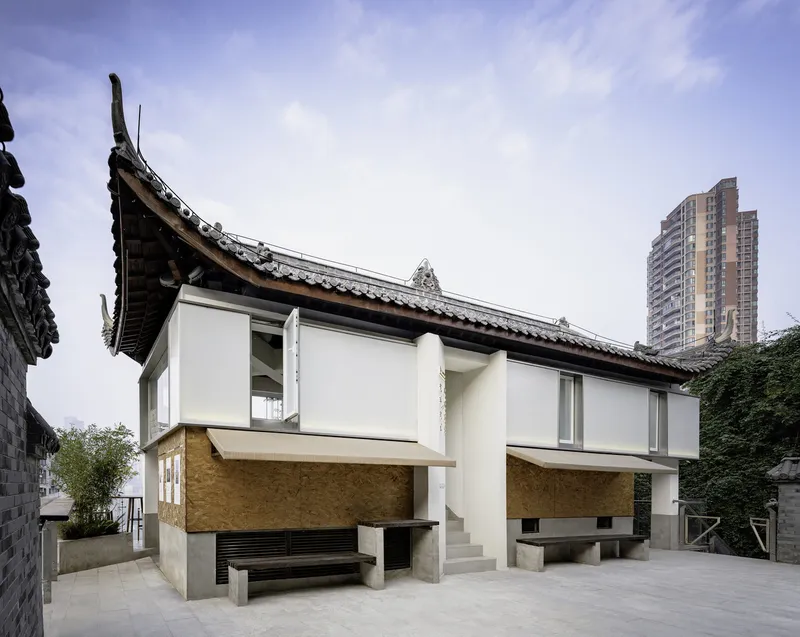 Side view of the curved tile roof with upturned eaves against a high-rise tower backdrop