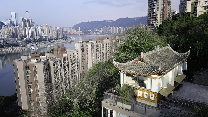 Aerial view of the traditional pavilion roof set among residential towers along the riverbank