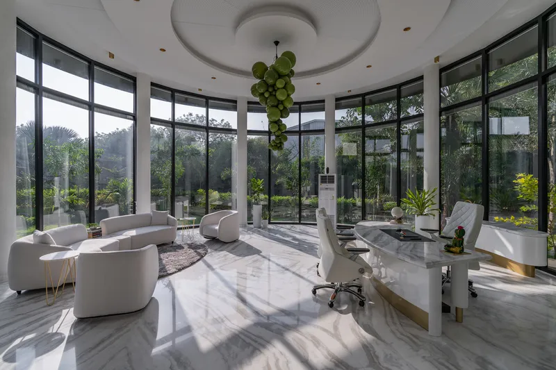 Interior of the circular glass-walled room with polished marble floors and hanging sphere lighting under recessed ceiling