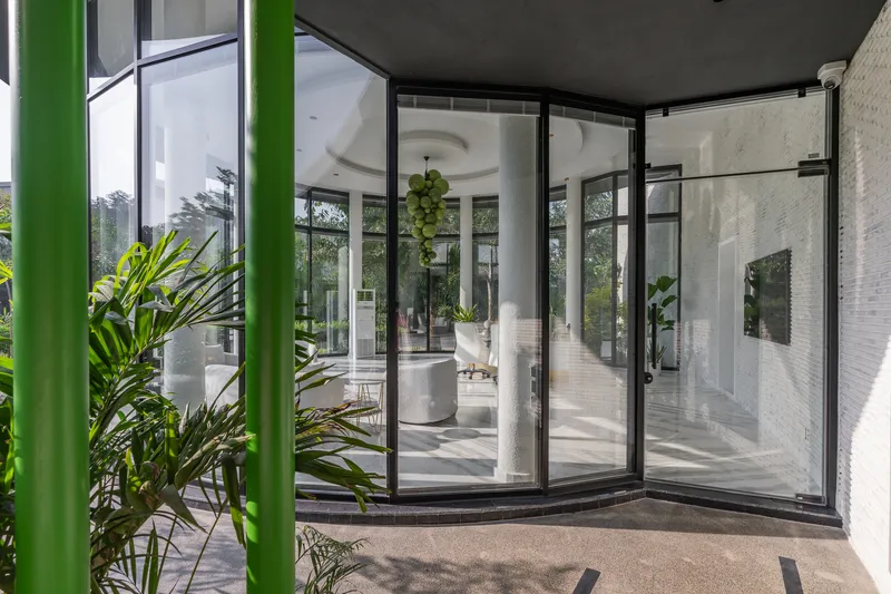 Glass pivot doors opening from the covered walkway into the light-filled interior living room