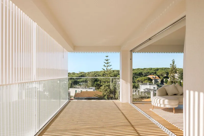 Terrace with slatted timber deck opening to landscape views through vertical louvered screen