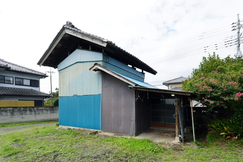 Exterior view of mixed blue and corrugated metal cladding beneath a tiled gable roof