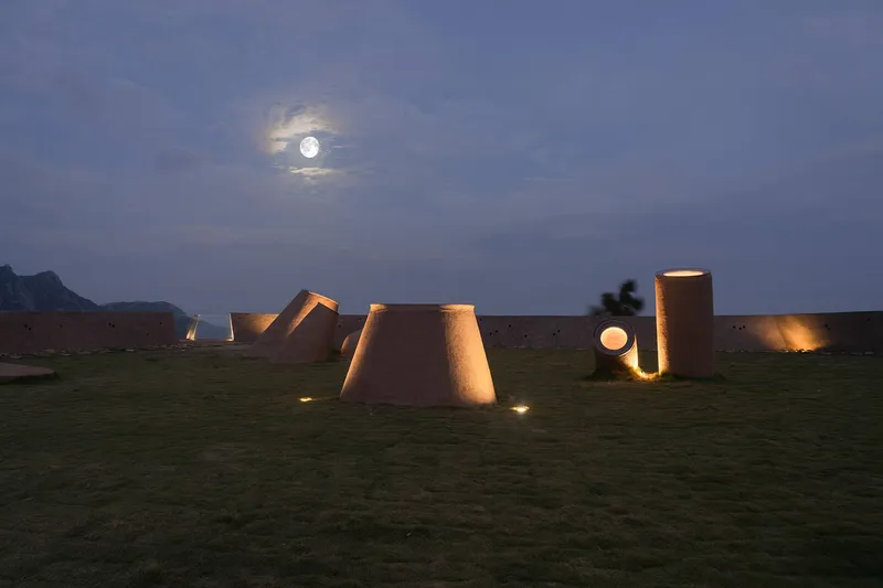 Cluster of tapered skylights puncturing the green roof under moonlight