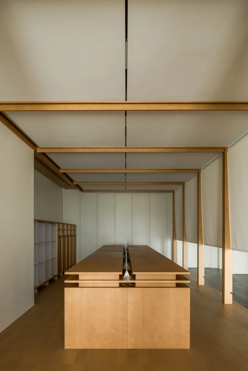 Plywood island with decorative object under timber frame archway and pendant light