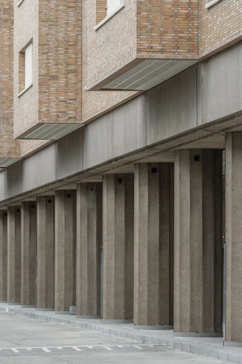 Ground level facade showing vertical precast concrete panels below brick residential tower