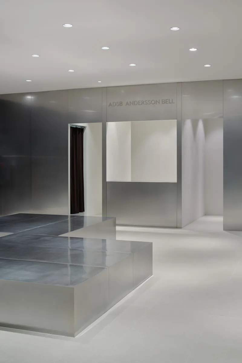 Retail interior with polished concrete floor and recessed ceiling lights illuminating grey paneled walls