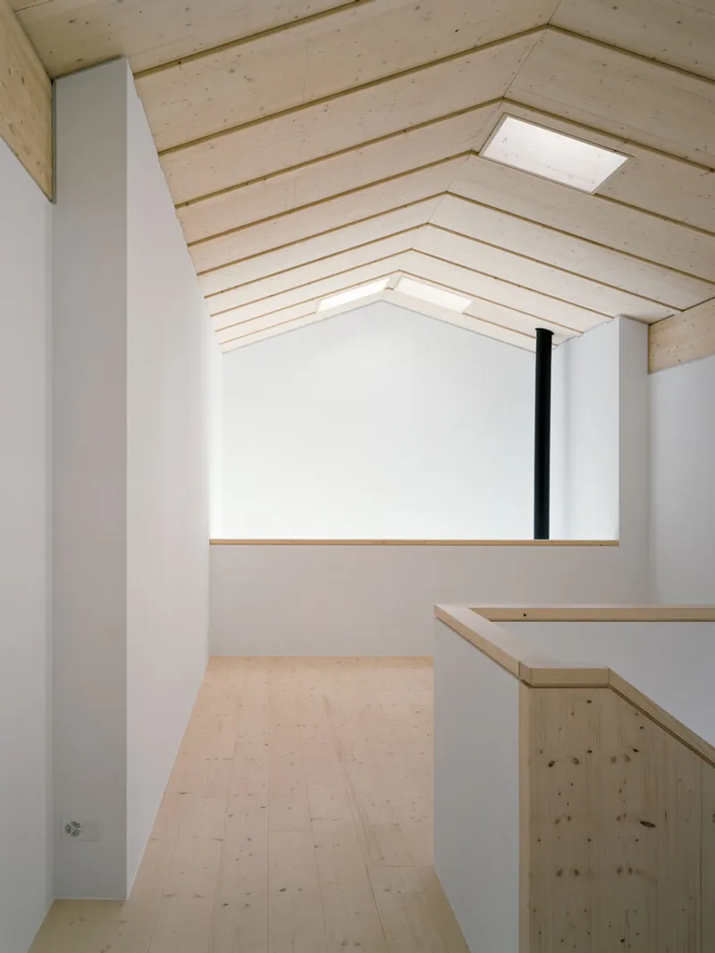 Upper level landing with horizontal timber planked ceiling and skylight above stair opening
