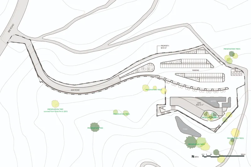 Site plan drawing showing building footprint with parking and existing trees along curved access roads