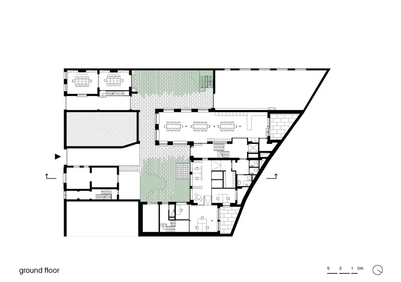 Ground floor plan drawing with central courtyard, dining areas, and rooms arranged around green outdoor space