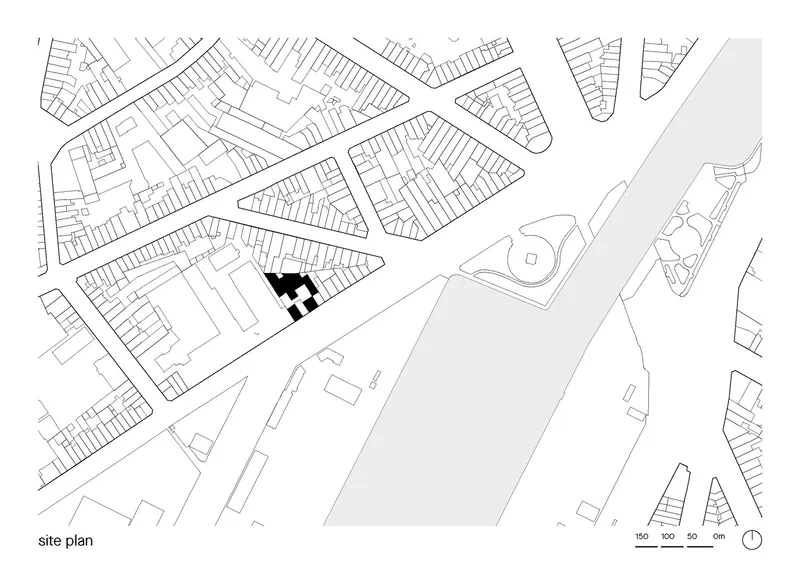 Site plan drawing showing the building footprint in black among surrounding streets and neighboring structures