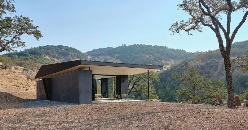 Distant view of the pavilion set in a clearing with surrounding oak trees