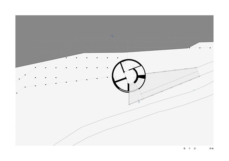 Site plan showing circular structure with access ramp on sloped terrain beside roadway