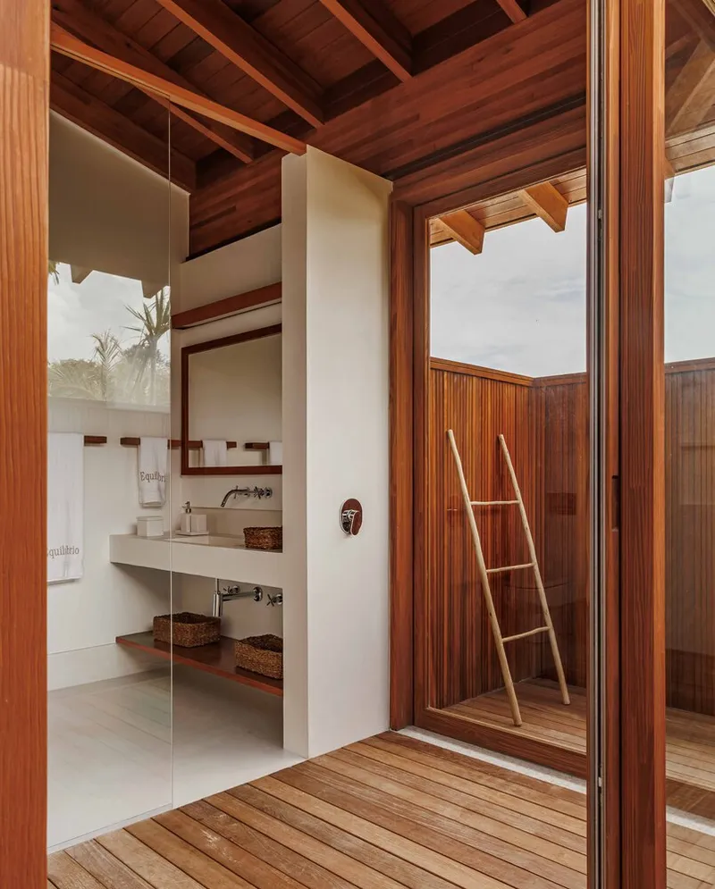 Bathroom with floating concrete vanity and timber deck opening to an enclosed outdoor shower courtyard