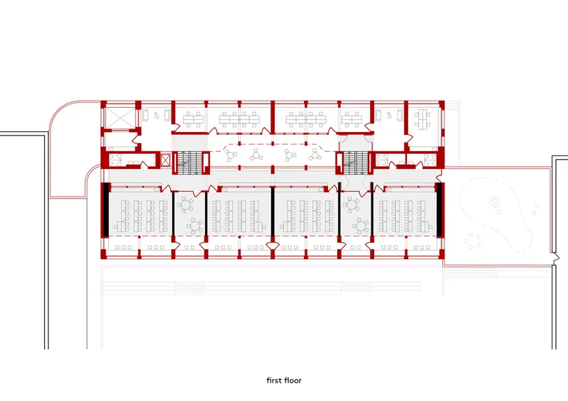 First floor plan drawing showing symmetrical layout with classroom rows and central corridor