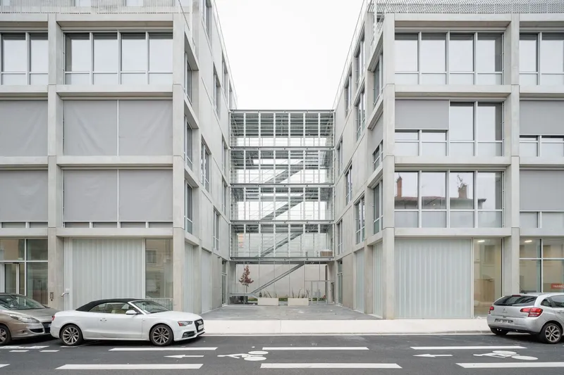 Symmetrical courtyard view framed by two residential wings with glazed circulation bridge connecting them