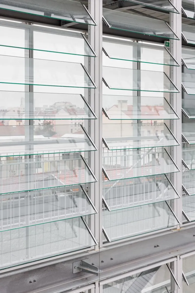 Glass louvres with aluminium frames tilted open to filter light and air