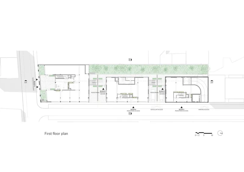 First floor plan drawing showing interior rooms and circulation with a linear green space along one edge