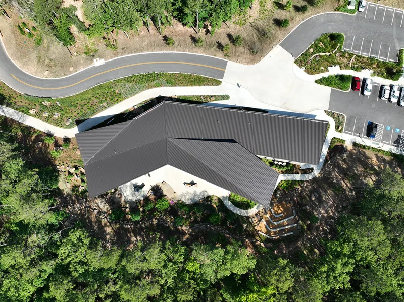 Aerial view of the angular dark roof with clerestory glazing and surrounding parking lot