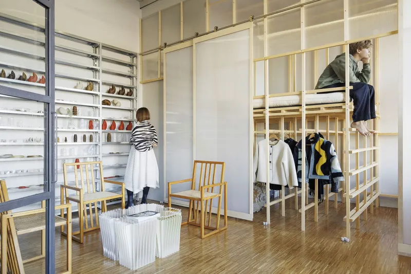 Retail interior with light timber gridded partitions displaying shoes and clothing