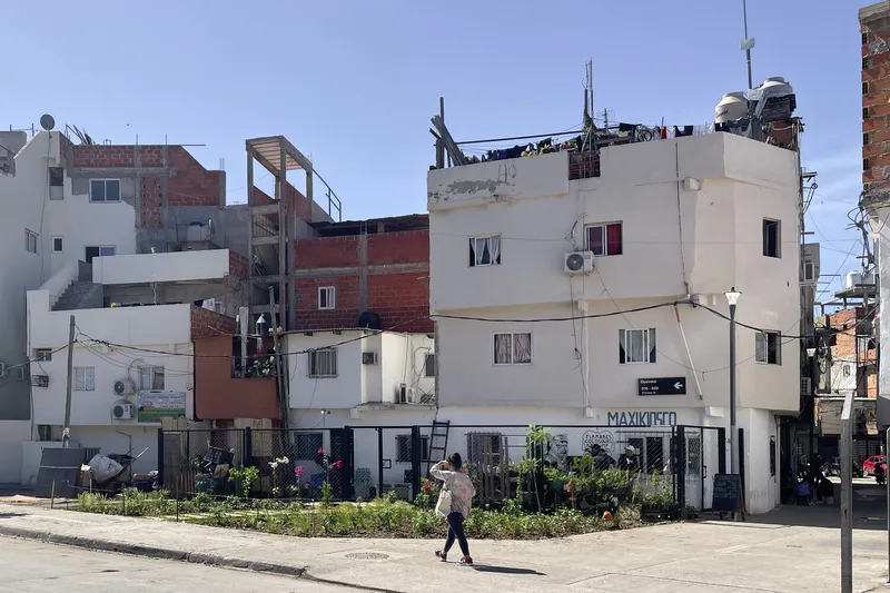 Corner view of the planted garden bed and white corner building with a pedestrian crossing