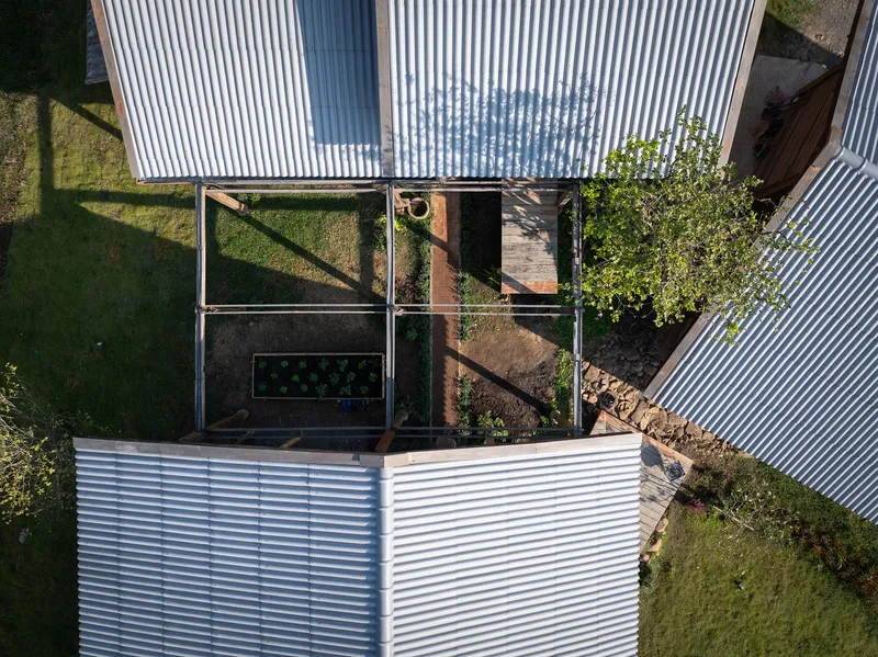 Aerial view of courtyard garden framed by corrugated metal roofs and timber decking