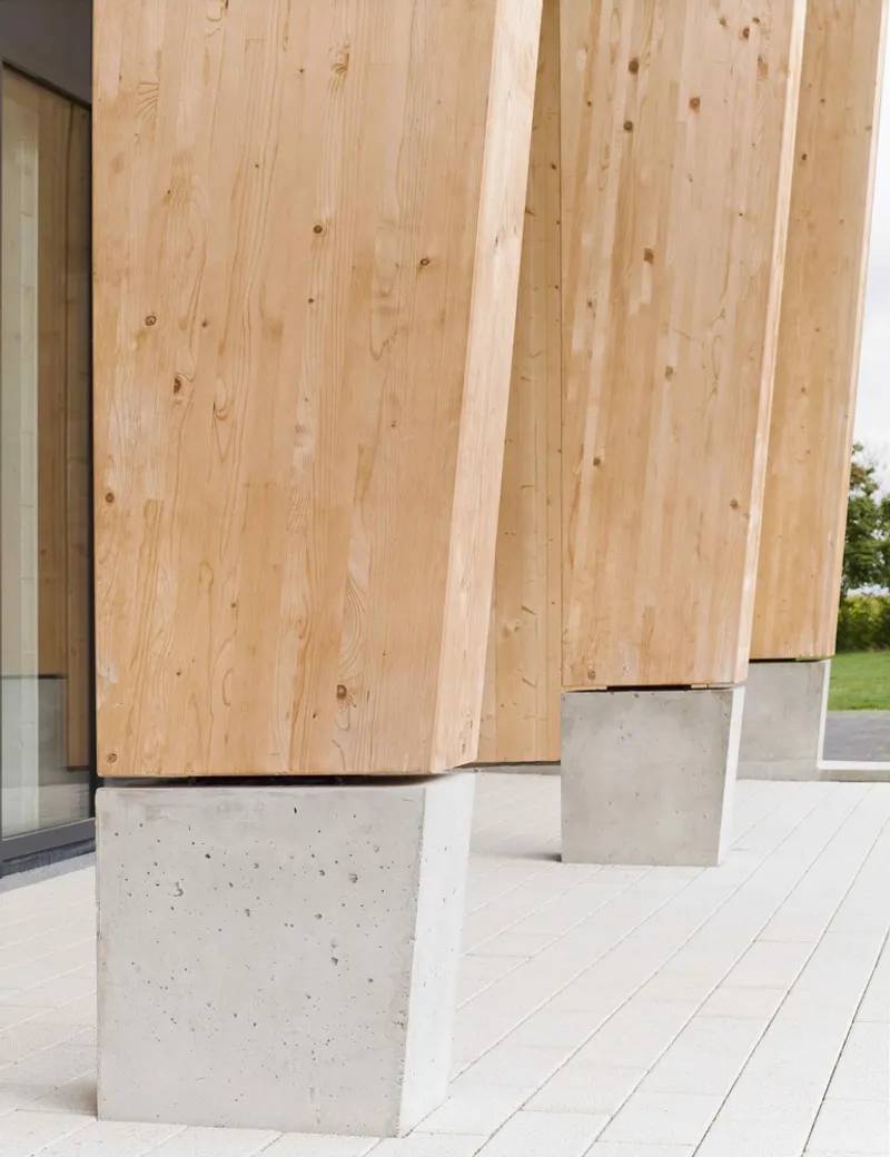 Timber columns with concrete bases supporting the overhanging roof on the terrace
