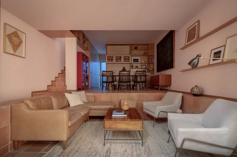 Sunken living area with terracotta tile floor and steps leading to the dining and kitchen zone