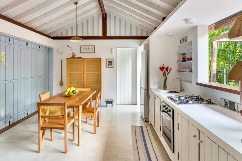 Kitchen and dining area with exposed timber rafters and painted tongue-and-groove ceiling boards