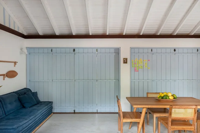 Interior with pale blue folding partition walls and exposed painted timber beams overhead