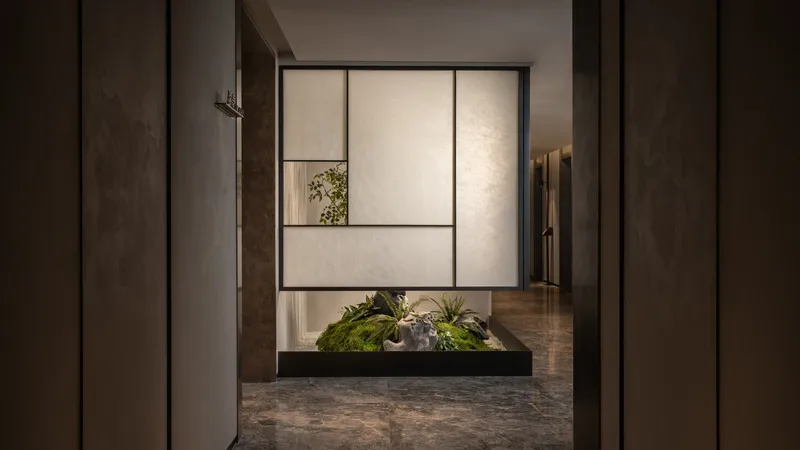 Framed view of interior planted courtyard with moss and stone through backlit translucent panels