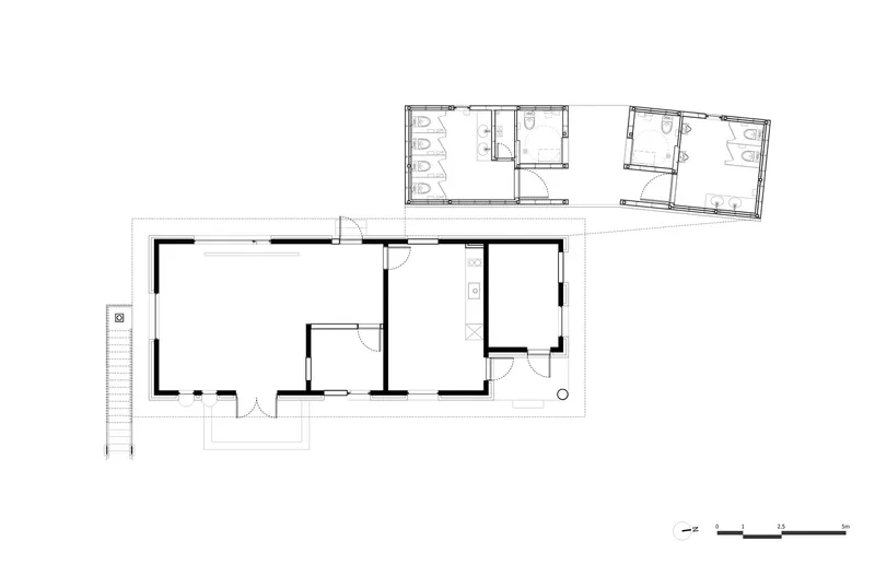Floor plan drawing depicting a rectangular residence with central rooms and an attached restroom block above