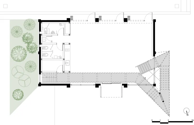 Floor plan drawing showing a commercial space with corner garden, restroom cluster, and diagonal stair tower