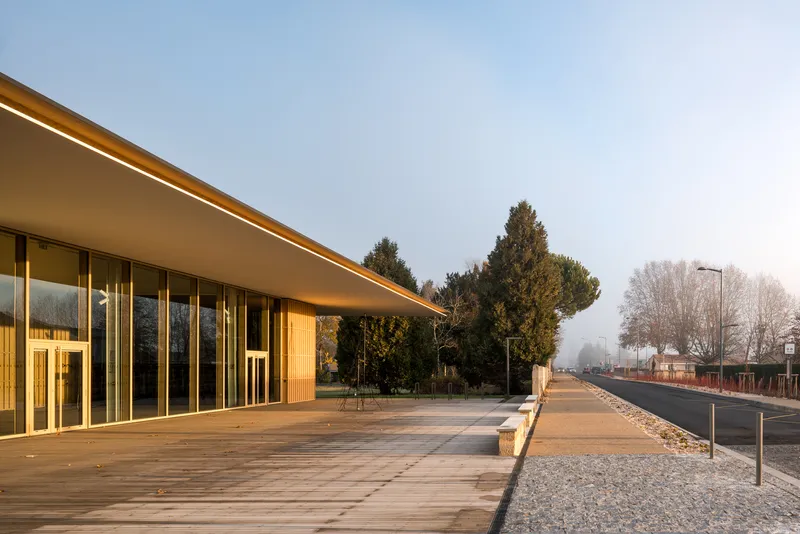 Timber deck and deep roof overhang along the facade at dusk