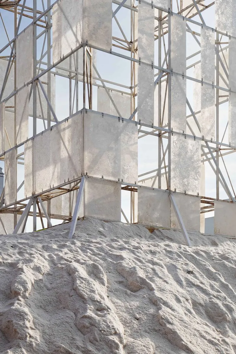 Close-up of the exposed timber frame structure and weathered concrete panels against white salt