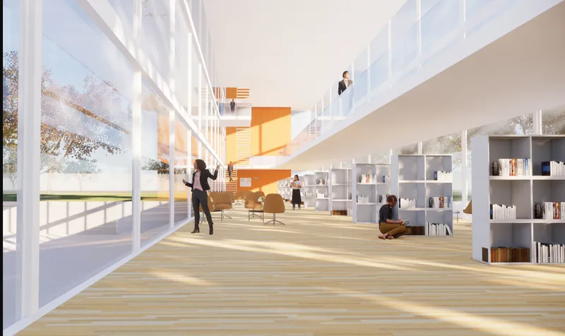 Double-height interior space with light wood flooring, white shelving, and people working in natural light