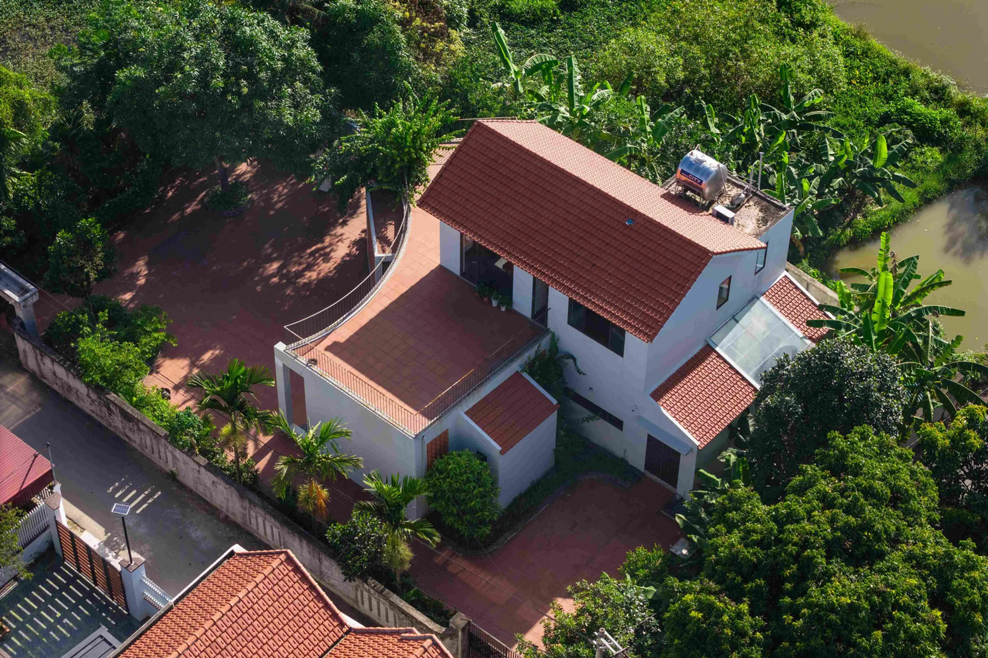 NH Village Architects Curves a Multi-Generational Home Around Courtyards in Rural Vietnam