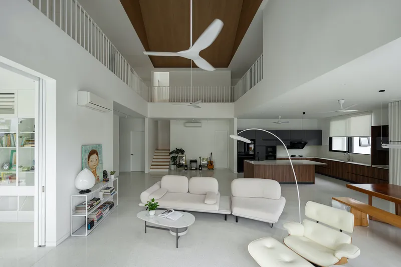 Open-plan living space with kitchen, dining and seating areas beneath the timber-lined double-height ceiling