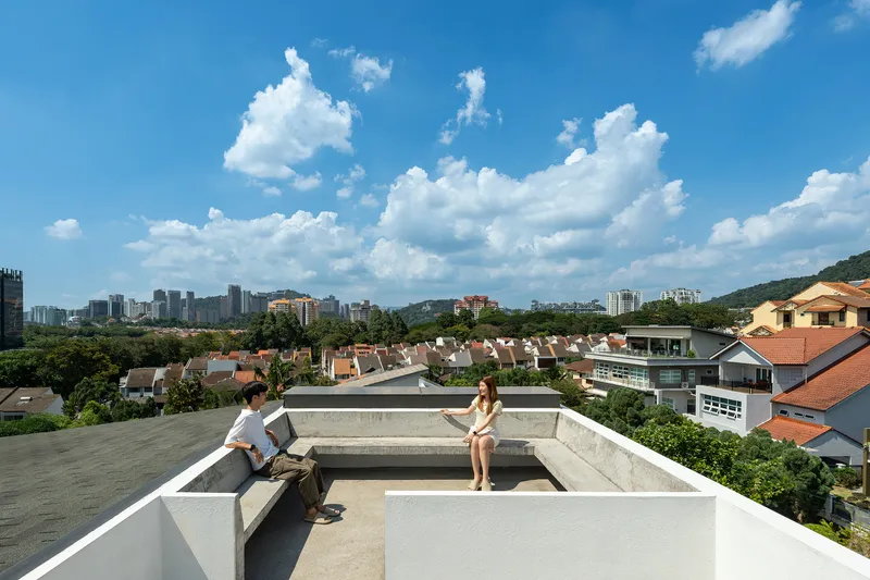 Rooftop terrace with raised concrete planters overlooking a residential neighborhood under afternoon clouds