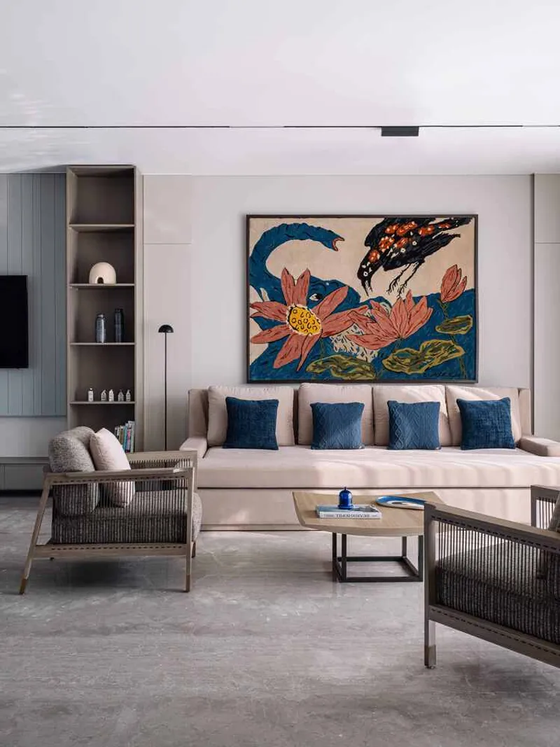 Living room with built-in shelving and floral artwork above a sectional sofa with blue cushions