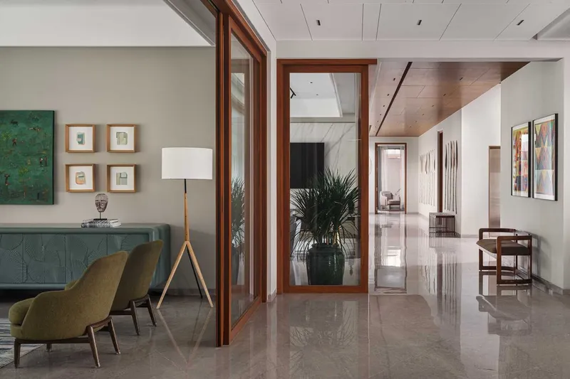 Interior hallway with timber-framed glass doors opening to polished marble flooring and planted urn