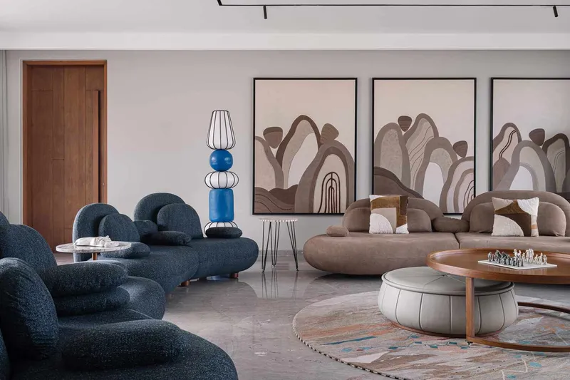 Lounge area featuring triptych artwork and curved modular seating around a chess set on marble floors