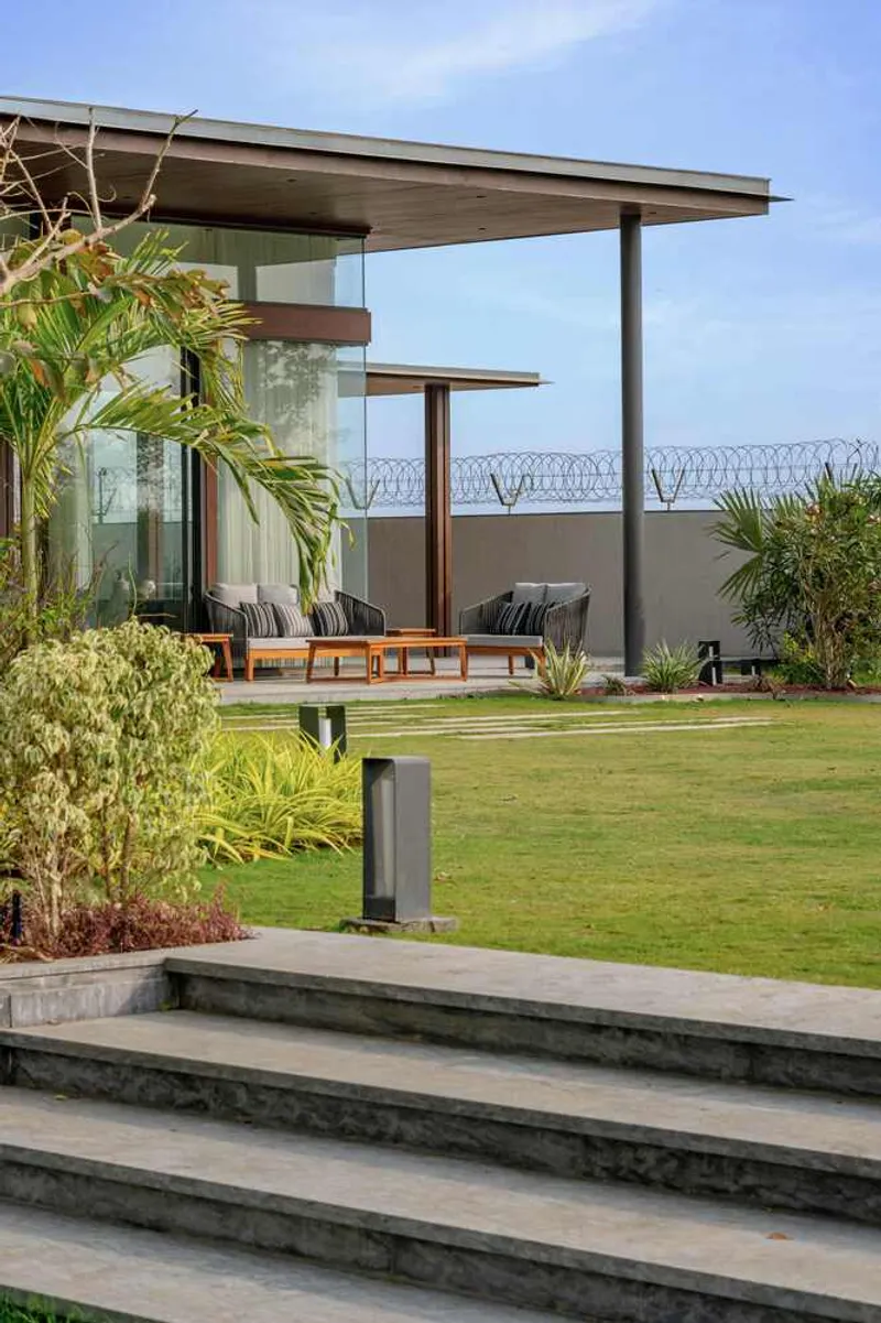 Covered terrace with cantilevered roof and seating platform overlooking the lawn and planted borders