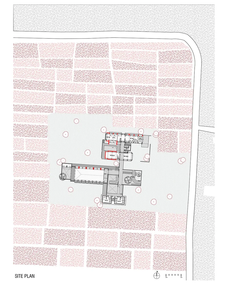 Site plan drawing showing building footprints within a courtyard surrounded by agricultural fields and trees
