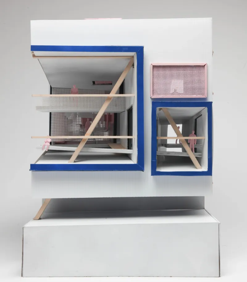 Physical section model with blue-framed openings, perforated pink screens and diagonal timber struts across white floors