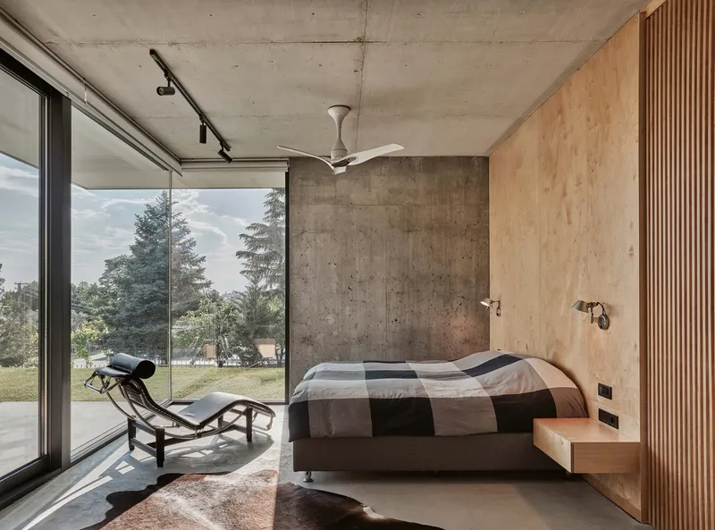 Bedroom with plywood slat wall and sliding glass door opening to a garden lawn