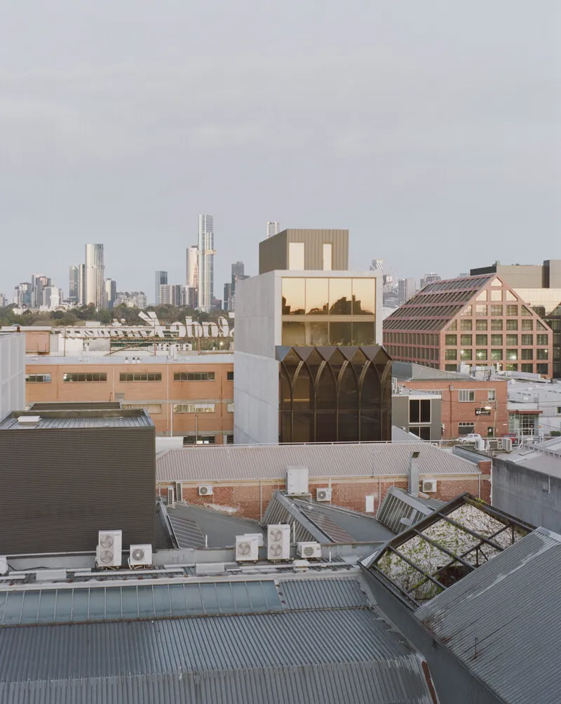 Rooftop view of the tower rising above surrounding warehouse buildings at dusk