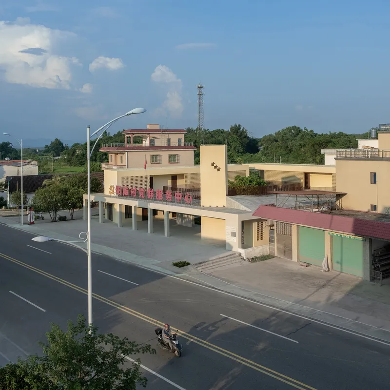 Elevated colonnade facing an empty roadway with streetlamp in the foreground at dusk