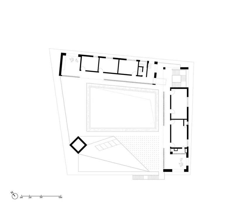 Upper floor plan featuring a triangular outdoor terrace and row of rooms along the northern edge