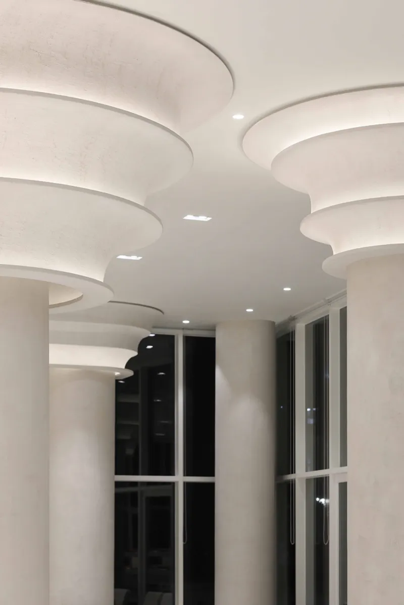 Close-up view of the layered circular ceiling discs with recessed lighting at night